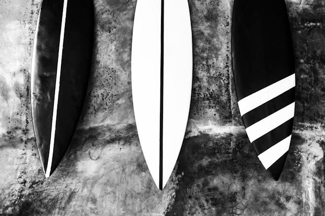 three surf boards, two with one stripe and one with three stripes