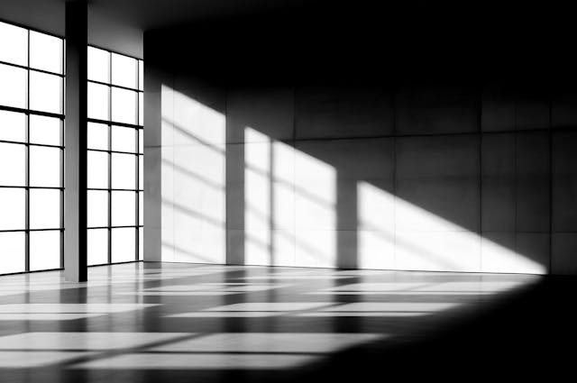 light shining through window of a room creating shadows on the floor