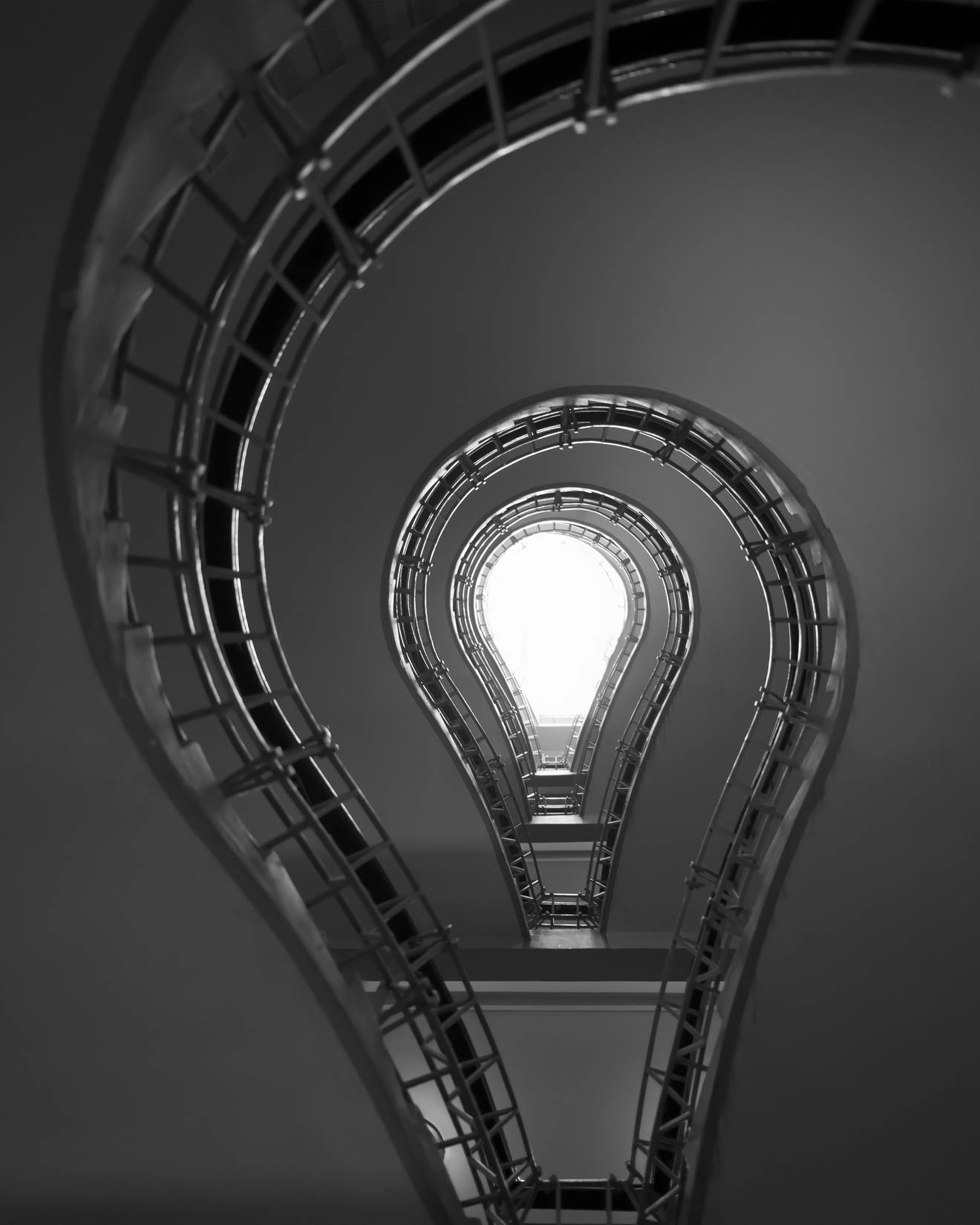 artistic view of lightbulb surround by a sweeping staircase