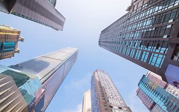 high office buildings filmed from bottom to top against blue sky