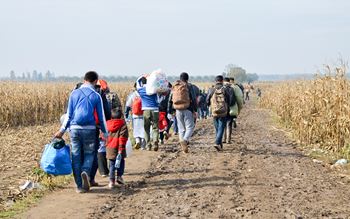Image of refugees walking carrying bags
