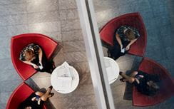 Bird's eye view of two colleagues sitting in red chairs 