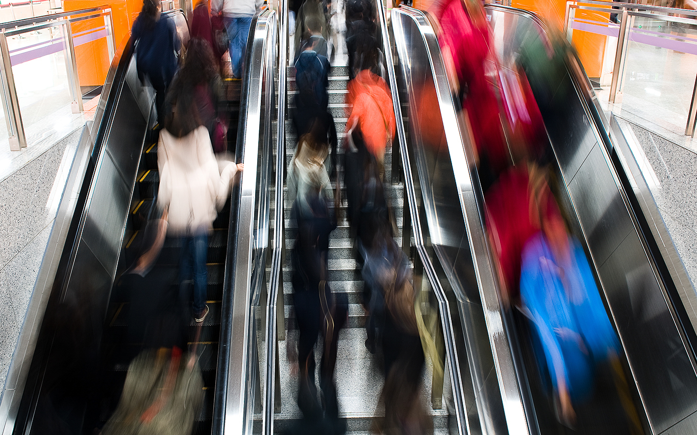 Image of commuters on an escalator 