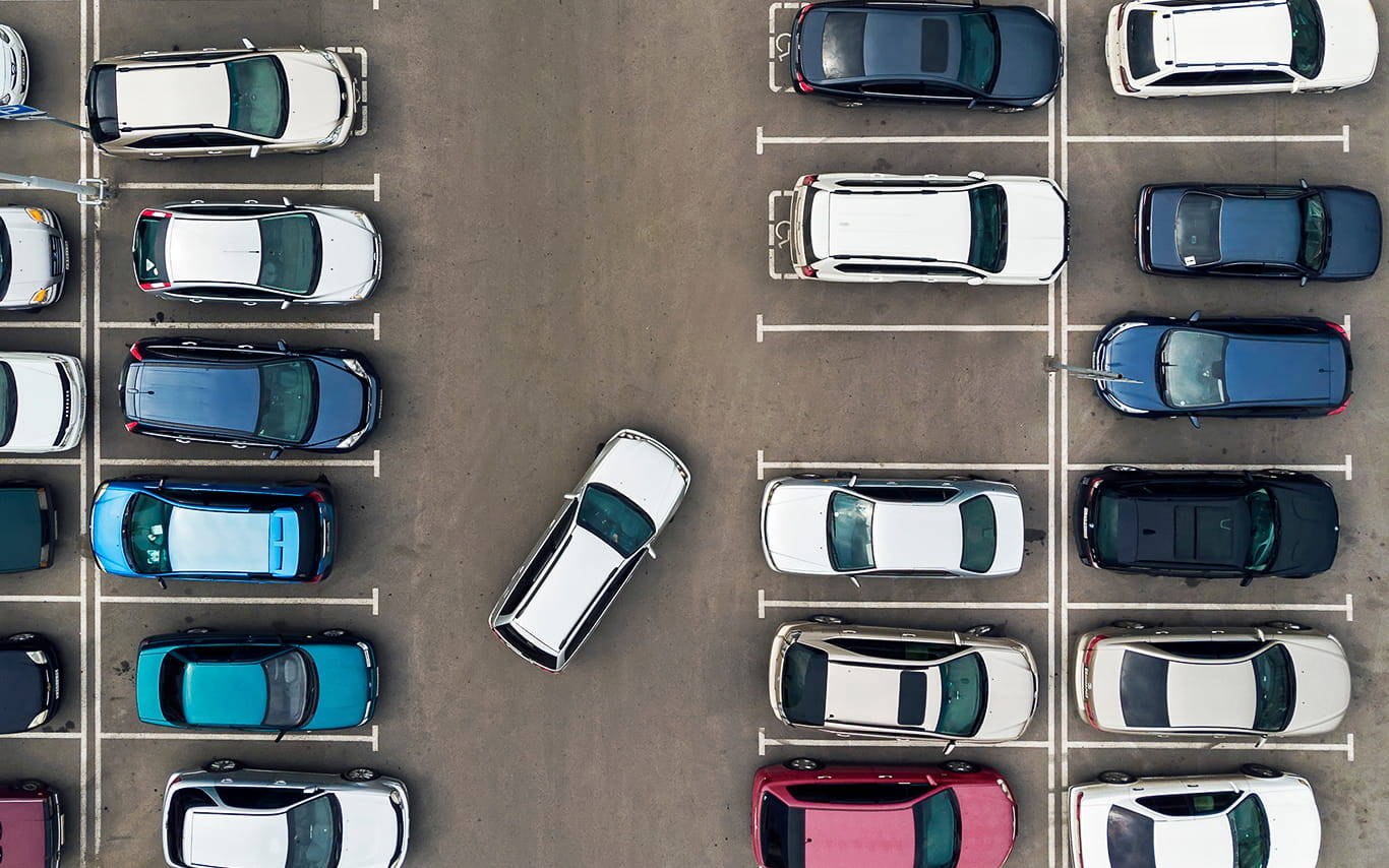 Aerial view of parking lot with car pulling into space