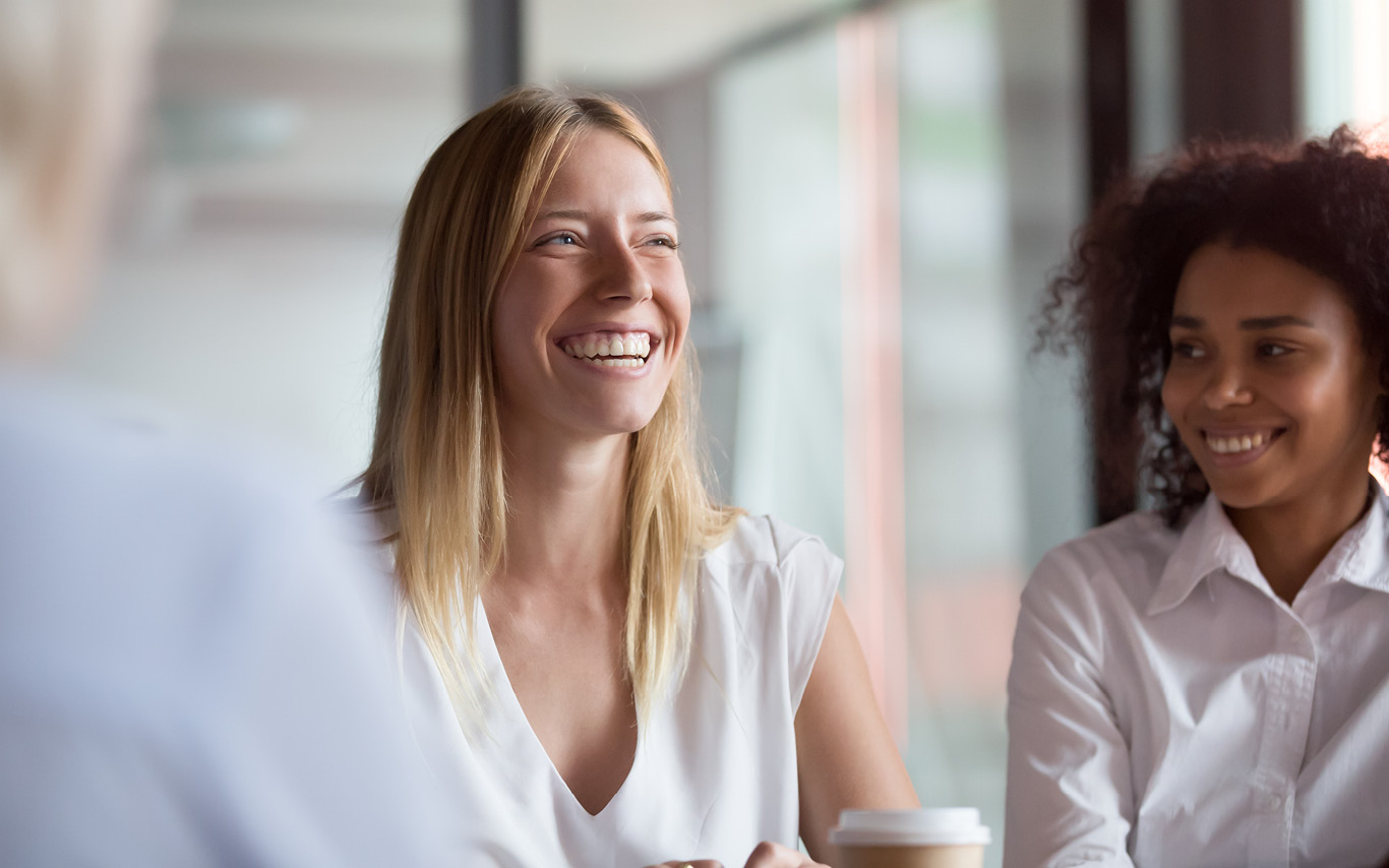 Two women smiling in office setting