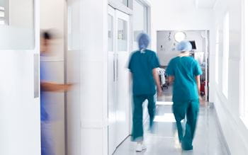 Motion Blur Shot Of Medical Staff In Hospital Corridor
