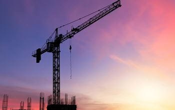 Large construction crane against a sunrise