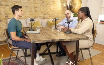 Image of three people talking around a table