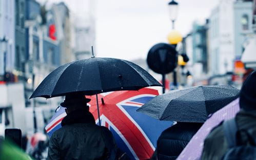 Image of crowded street with union jack umbrella in crowd