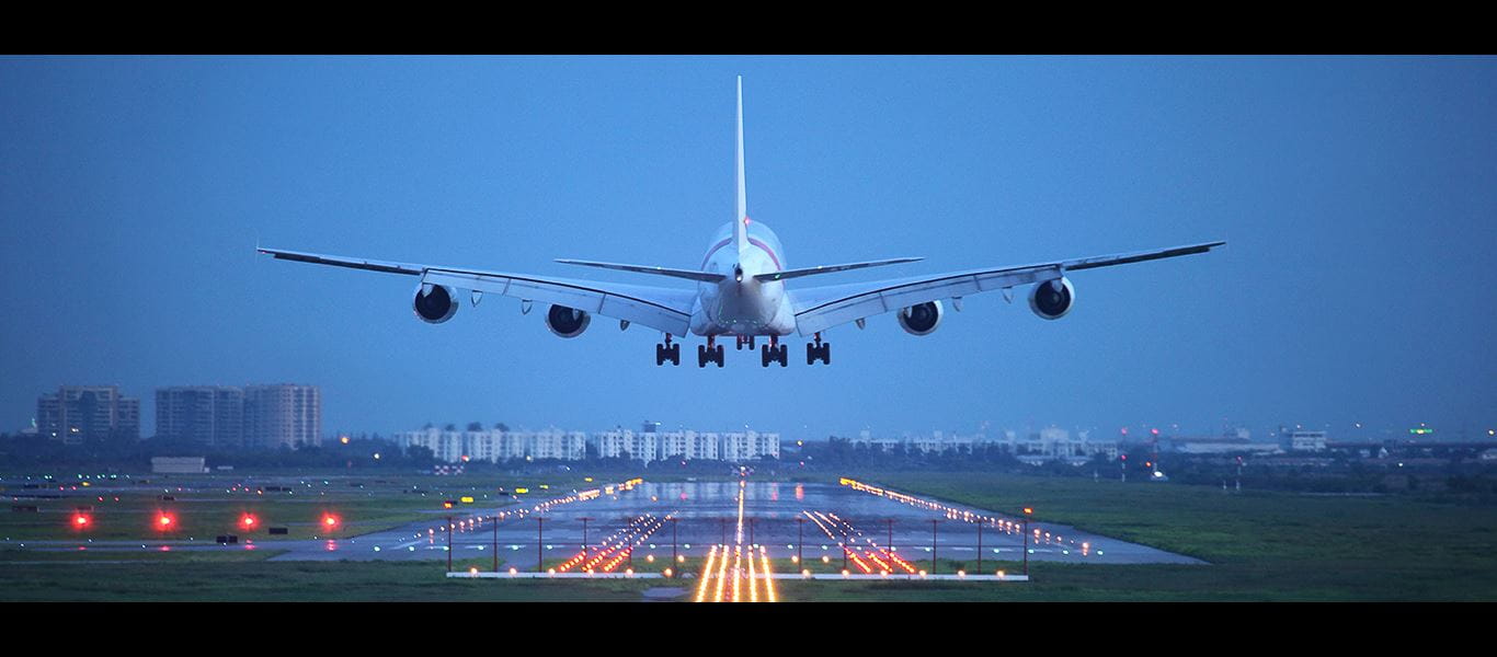 Image of airplane taking off from lit runway in an evening shot