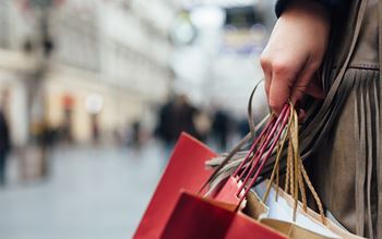 image of shopping bags in a female hand with high street in the background