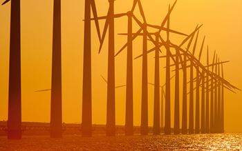 Windmills in sea in sunset setting