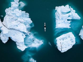 Kayak among icebergs