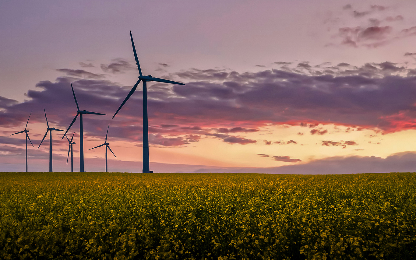 Wind turbines against a a sky at sunset
