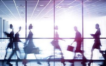 Silhouettes of business people walking past a window