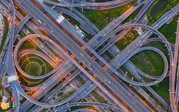 Aerial view of highway at rush hour at night time with car trail and traffic.