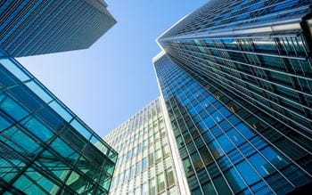 High rise glass buildings against a blue sky