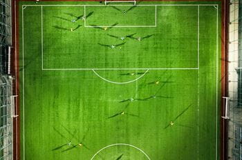 Top down image of a football team playing at night with flood lighting