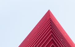 A modern red building against a blue sky