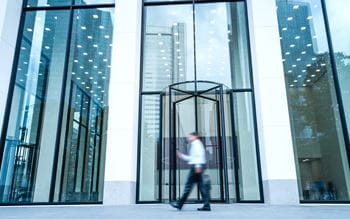 entrance of modern building in Frankfurt with  a business man walking past
