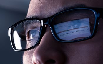Man in glasses looking at screen