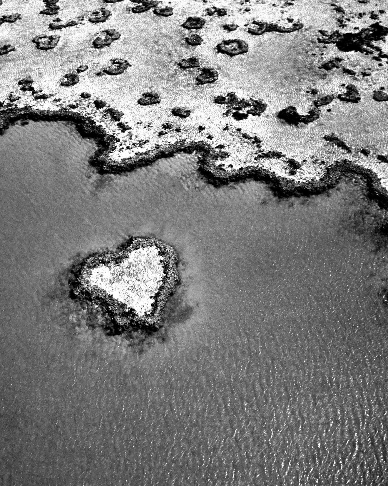 Black and white image of a small heart shaped island in the waters of Australia