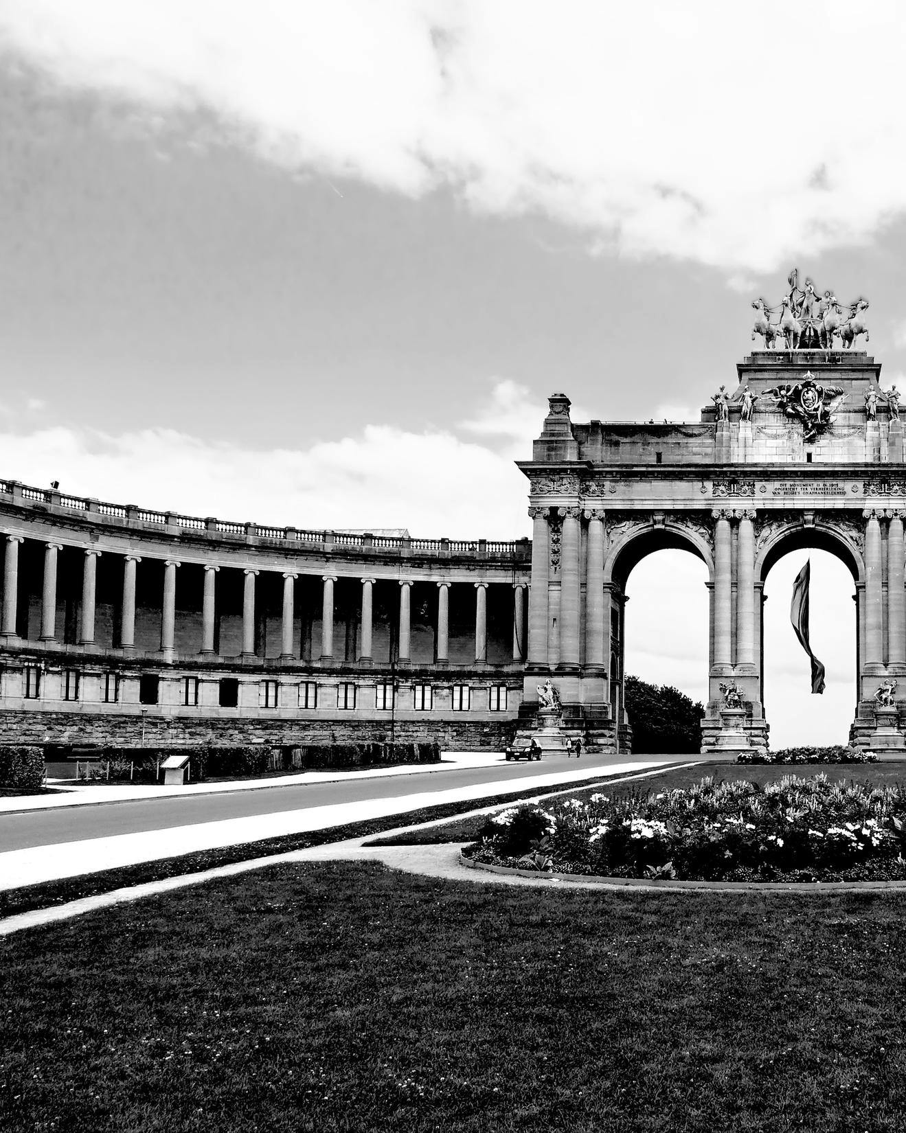 Black and white image showing a monumental arch and garden in Belgium