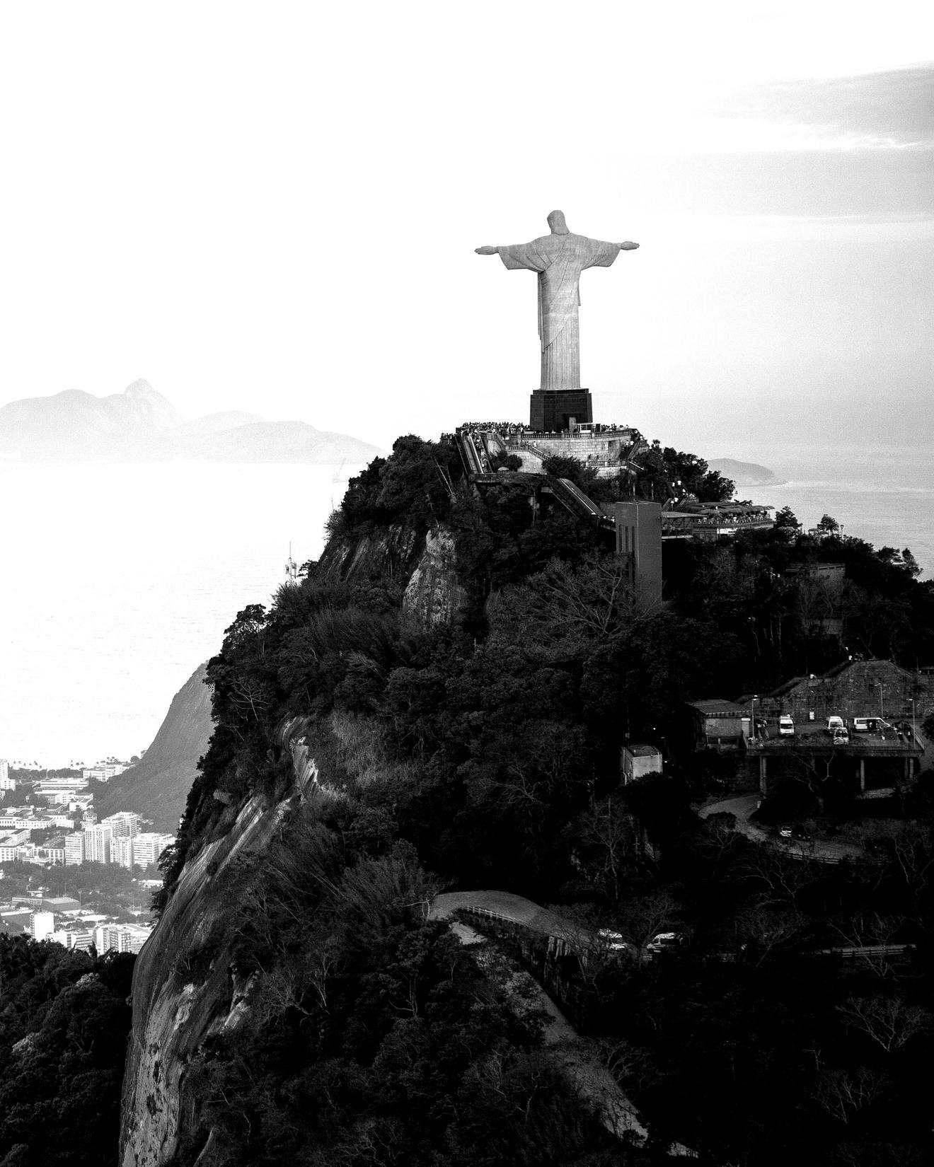 Black and white image of Christ the Redeemer statue on a mountain overlooking the city of Rio de Janeiro