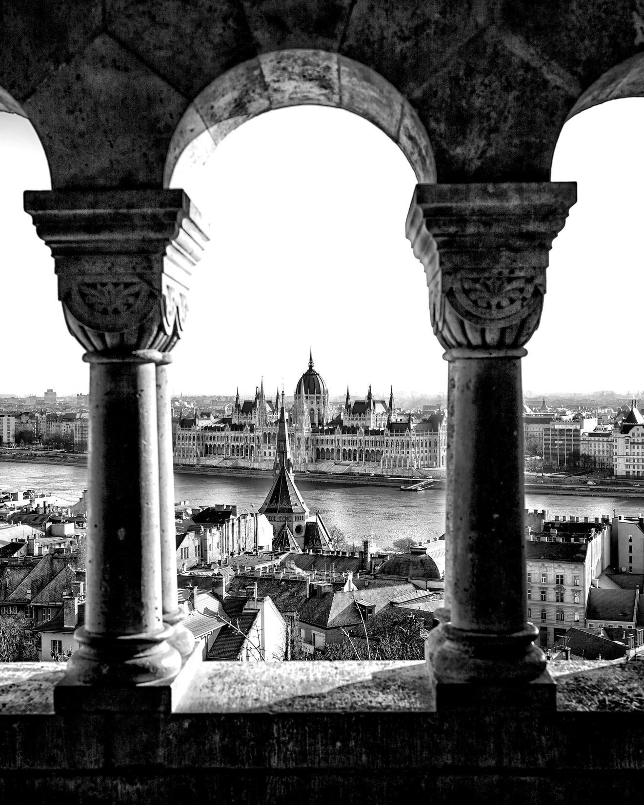 Black and white image taken through a triple window looking over the capital city of Hungary