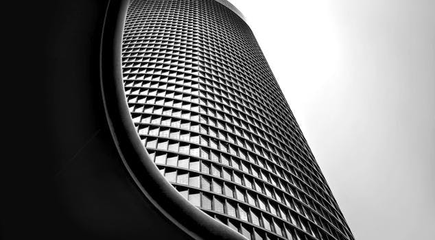 Office tower financial center in Madrid with view from the ground to the sky with clouds, lines of modern architecture in black and white