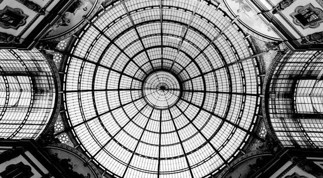 View from below of interiors, vaulted glass ceilings, facades and dome of the famous shopping arcade Galleria Vittorio Emanuele II